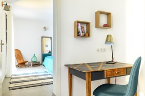 A modern room with a wooden desk, a chair, a lamp, and two shelves with books and decorative items. - LOFT VILLAGE HOUSE+AIR CONDITIONING+TERRACE, NEAR THE GOLF COURSE. (Vernègues)