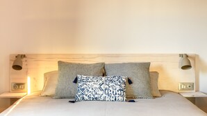 A neatly made bed with patterned pillows and two wall-mounted lamps on either side. - LOFT VILLAGE HOUSE+AIR CONDITIONING+TERRACE, NEAR THE GOLF COURSE. (Vernègues)