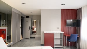 A hotel room with a bed, a desk, a chair, a TV, and a mirror. - Voir Hotel Pera (Istanbul)