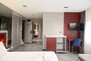 A hotel room with a bed, a desk, a chair, a TV, and a mirror. - Voir Hotel Pera (Istanbul)