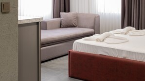 A modern hotel room with a bed, a sofa, and a desk. - Voir Hotel Pera (Istanbul)