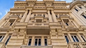 A large, ornate building with classical architecture, featuring tall columns, detailed carvings, and multiple windows. - Voir Hotel Pera (Istanbul)