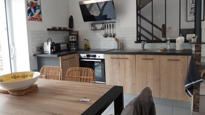 Een moderne keuken met houten kastjes, een ingebouwde oven en een groot raam.