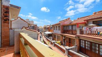 A narrow street with traditional buildings, a visible laundry line, and a clear blue sky.