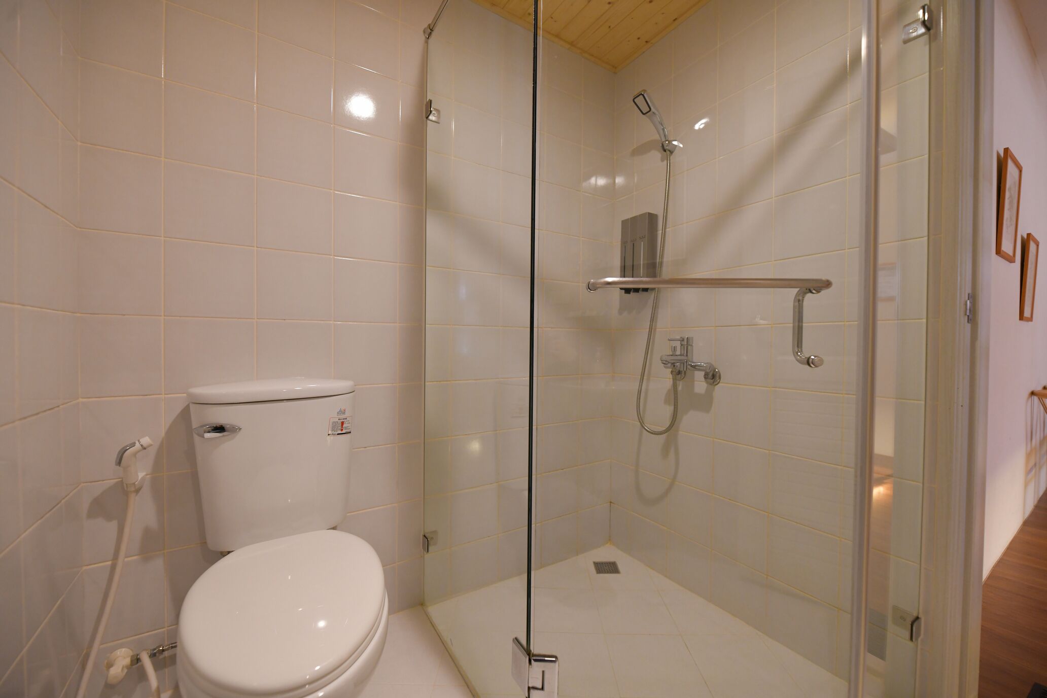 A modern bathroom with a glass-enclosed shower, a white toilet, and a tiled floor.