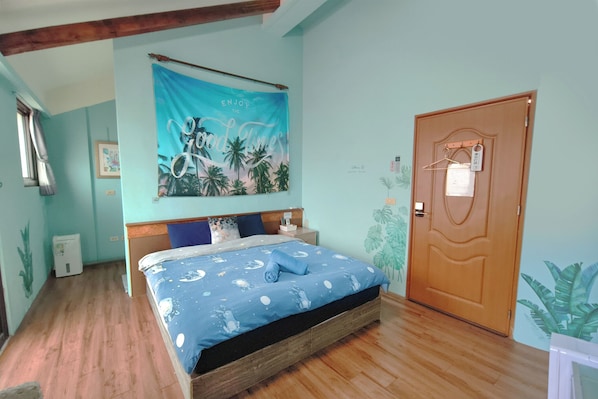 A bedroom with a bed, a wooden door, and a wall tapestry.
