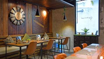 A restaurant with wooden walls, a large clock, and a projection screen displaying 'keep smiling'.