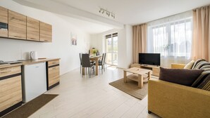 Un apartamento moderno con cocina, comedor, sala de estar y un balcón.