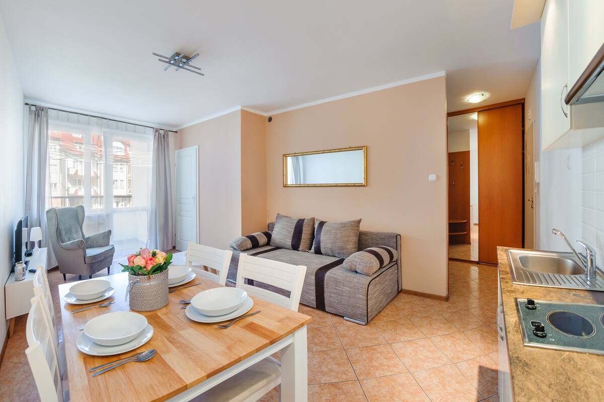 Un espacio habitable compacto con comedor, kitchenette y sofá.