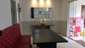 En moderne stue med en rød sofa, et sort sofabord og en dekorativ vase med blomster.