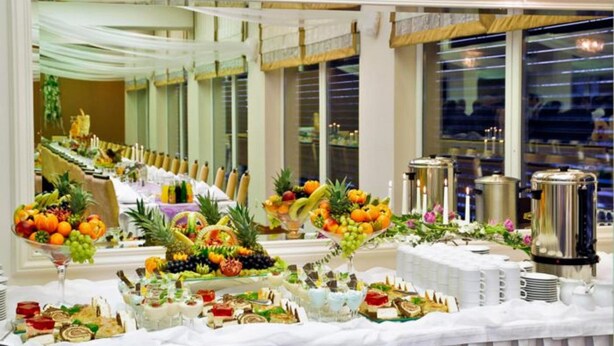 A buffet setup with various food items and beverages, including fruits, pastries, and hot drinks, arranged on a table. - Hotel Gniecki (Pruszcz Gdanski)