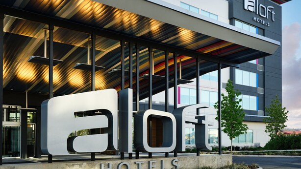 Un moderno edificio de hotel con un llamativo letrero de 'eLoft Hotels'.