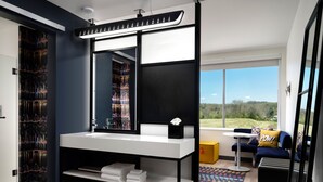 Un baño moderno con un espejo grande, un lavabo blanco y un perchero para toallas.