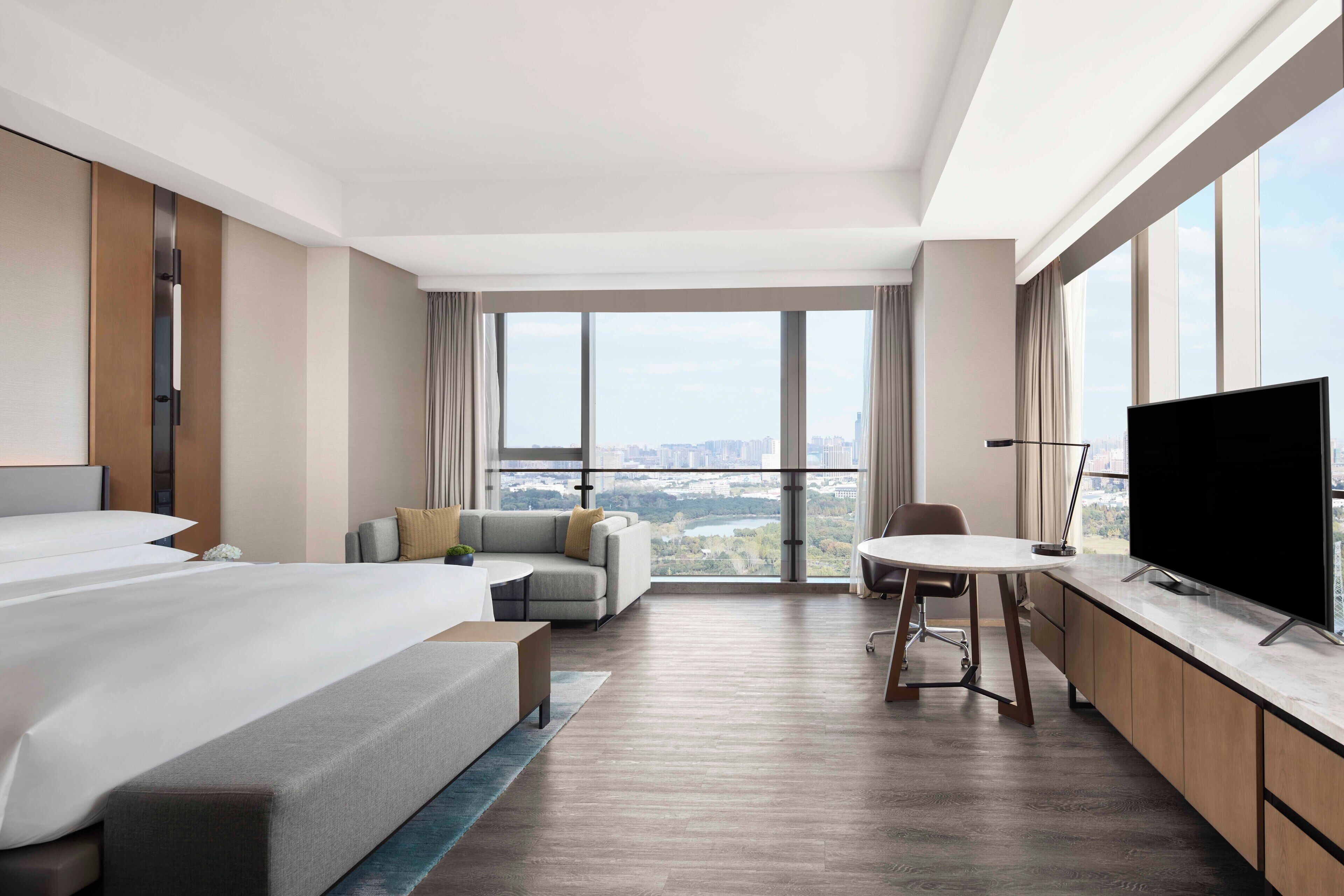 Une chambre d’hôtel moderne équipée d’un grand lit, d’un canapé, d’une table à manger et d’un téléviseur.