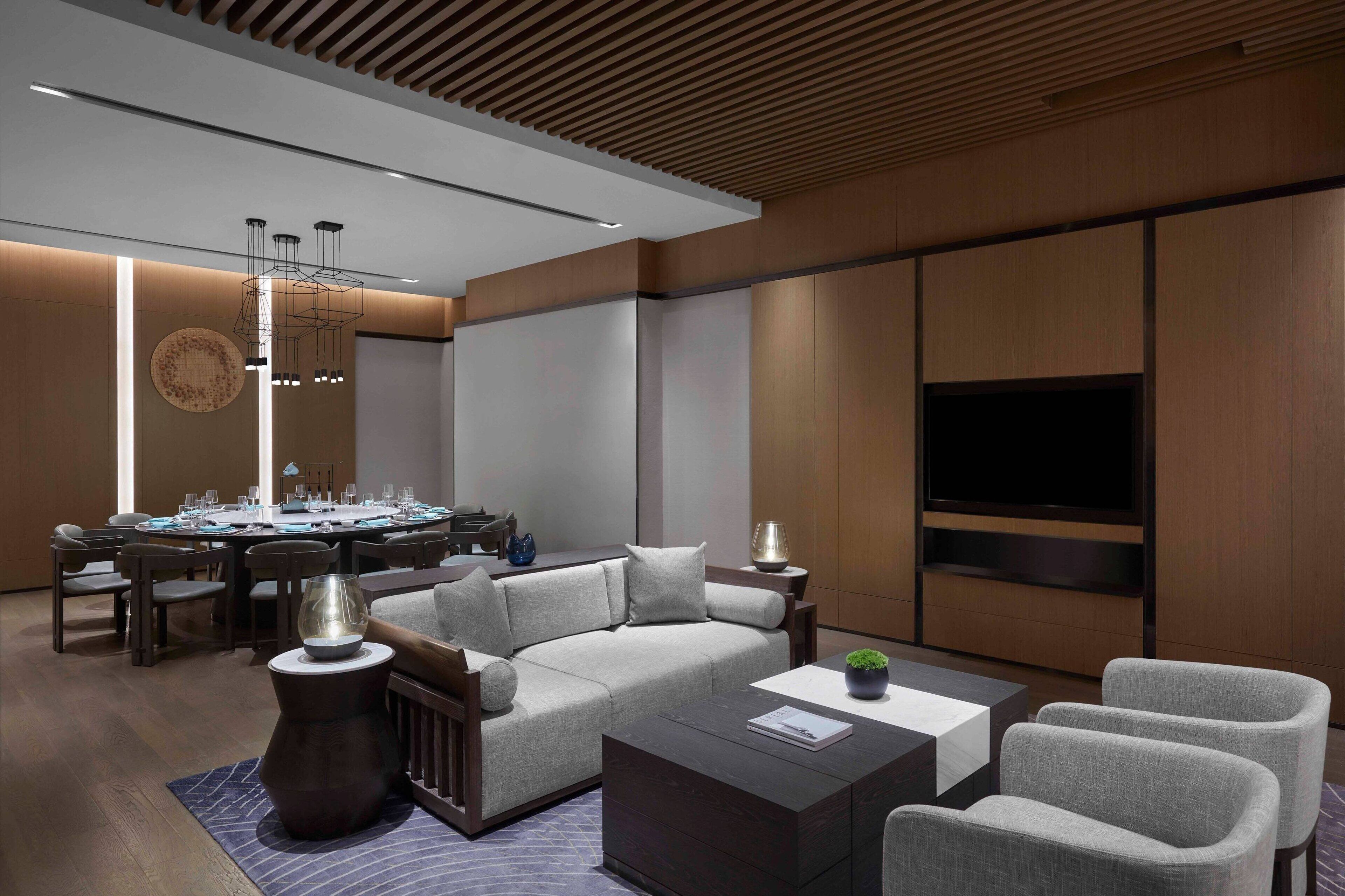 A modern living room with a sectional sofa, a coffee table, and a TV mounted on the wall.