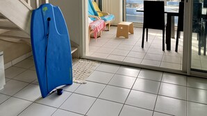 Ein Zimmer mit einer Treppe, einer Schiebetür zu einem Außenbereich mit Tisch und Stühlen und einem blauen Gegenstand, der an der Wand lehnt.