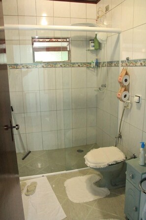 A bathroom with a shower, toilet, and sink.