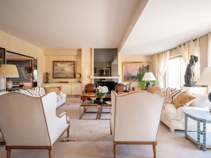 A spacious living room with a sofa set, a coffee table, and a fireplace.