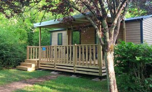 Eine kleine Holzhütte mit einer Holzterrasse und Stufen zum Eingang.