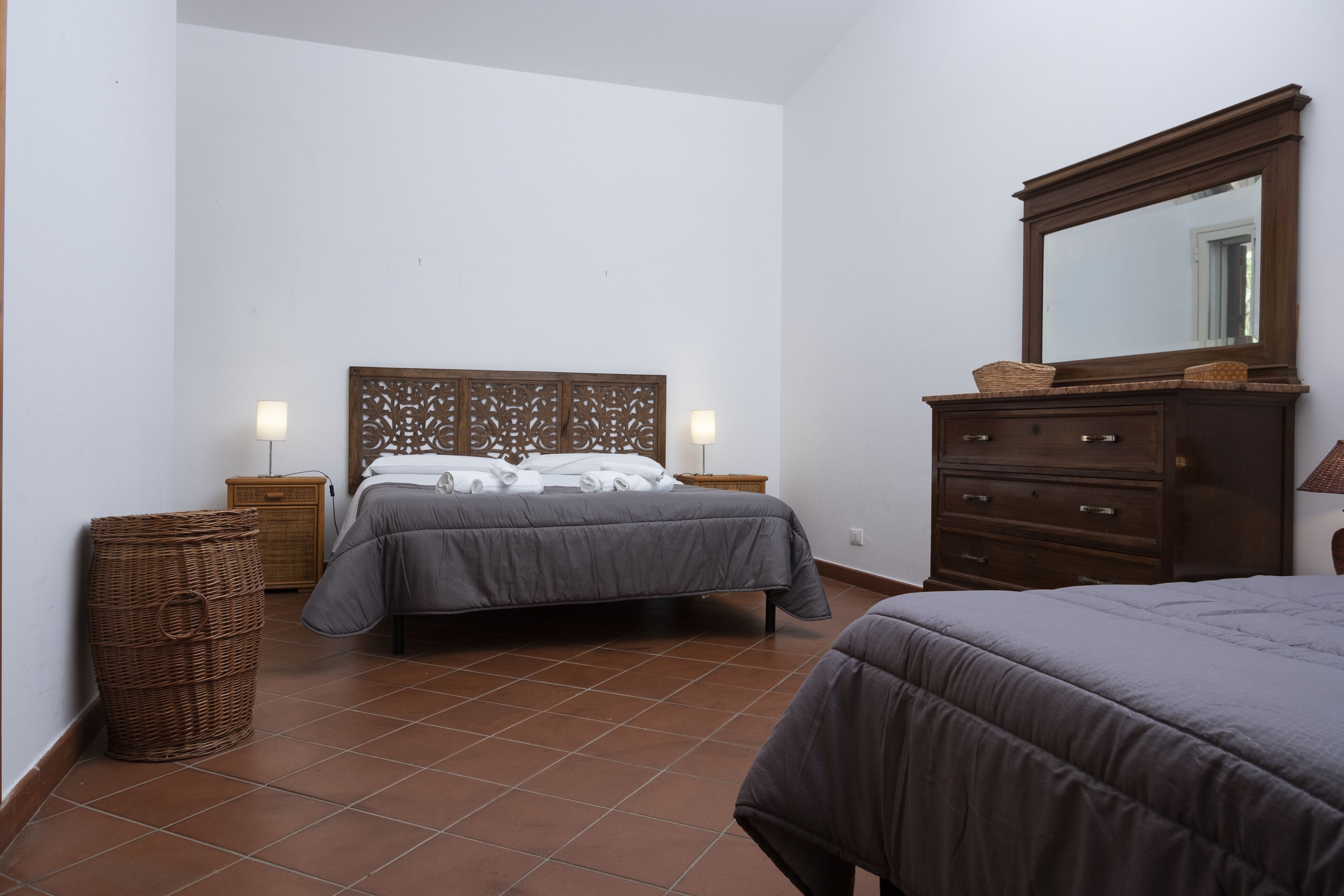 Une chambre à coucher avec un lit, une commode et des tables de chevet.