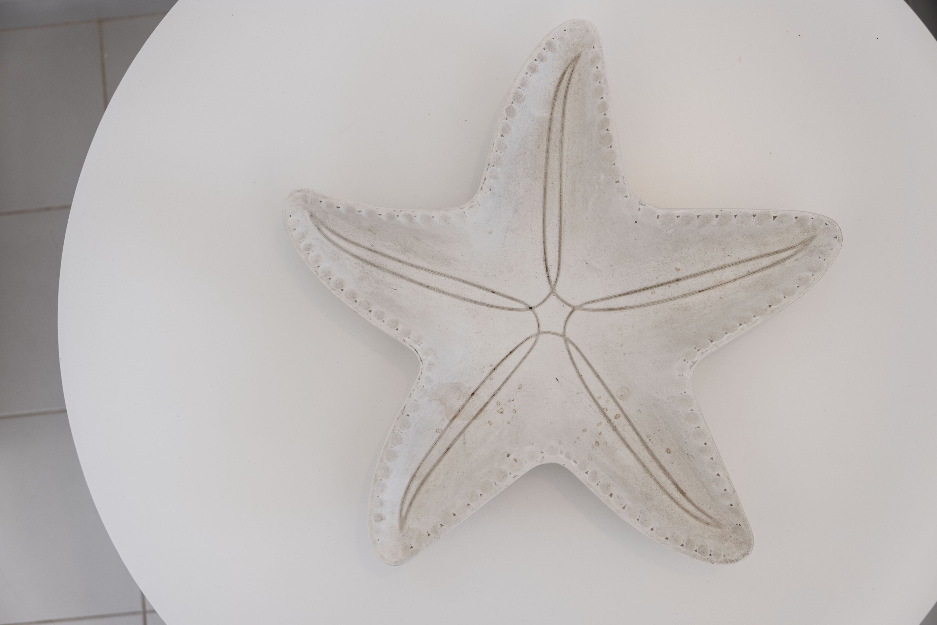A white starfish decoration on a white surface.