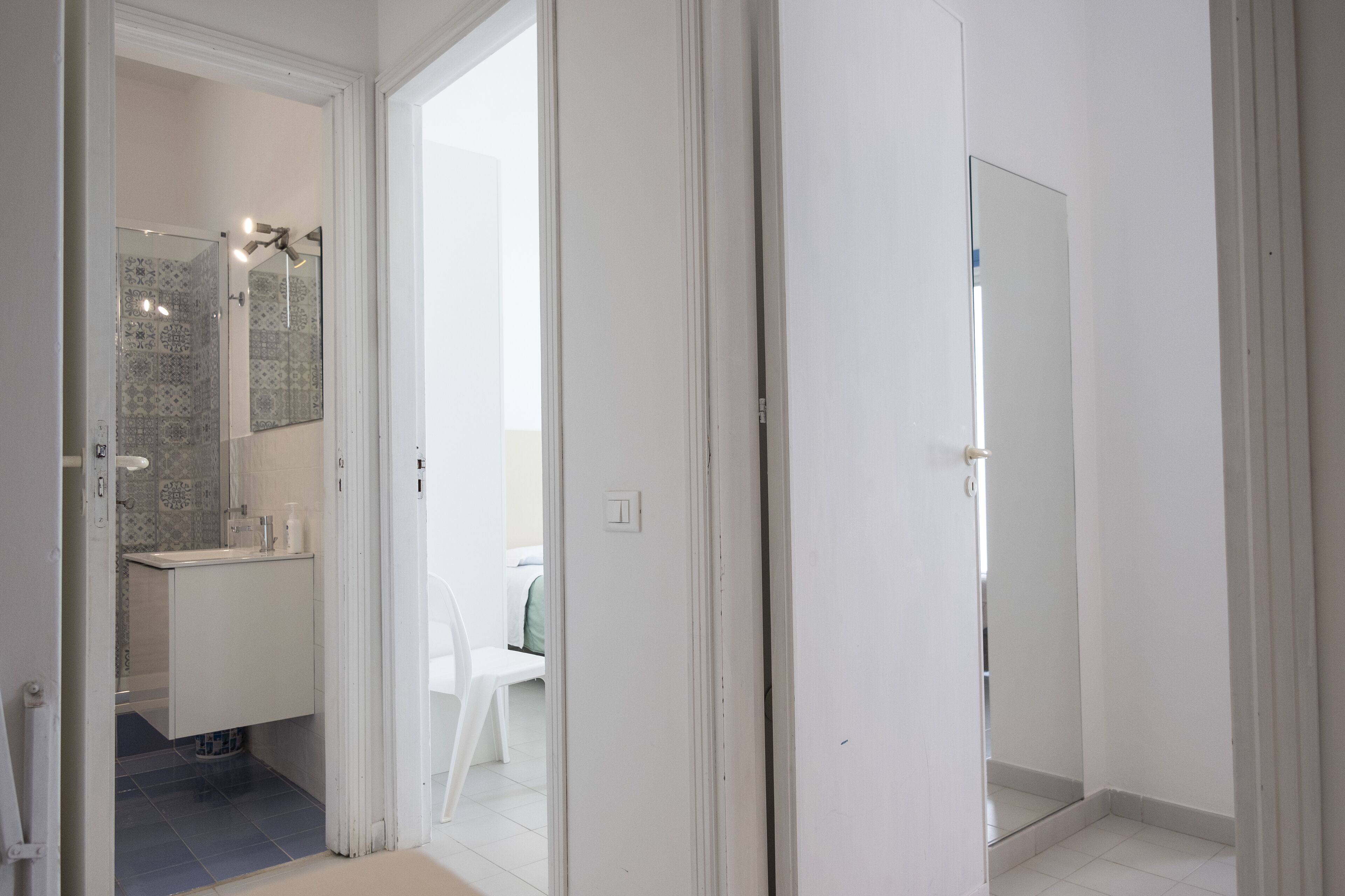 A modern bathroom with a shower, a toilet, and a sink. There is a mirror above the sink and a ceiling fan.