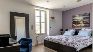 A bedroom with a bed, a desk, and a chair.