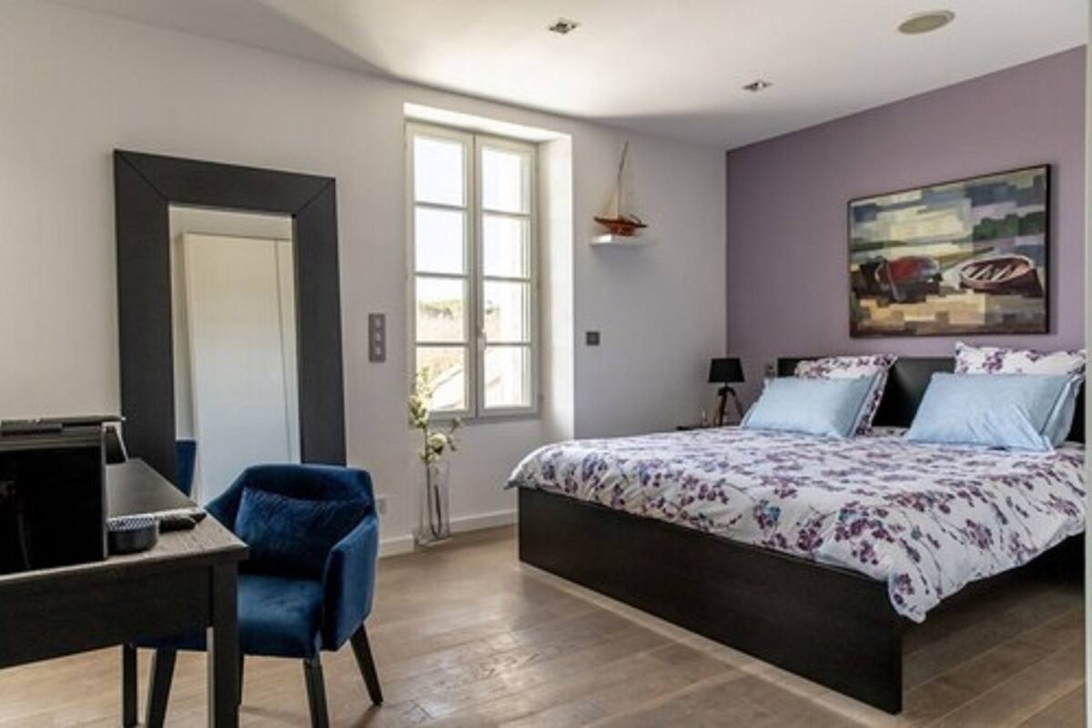 Een slaapkamer met een bed, een bureau en een stoel.
