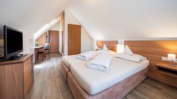 Una habitación de hotel moderna con una cama grande, un escritorio y una televisión.