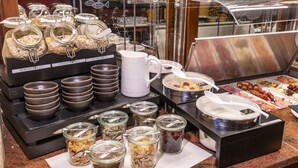 En buffetopstilling med diverse retter og serveringsbestik.