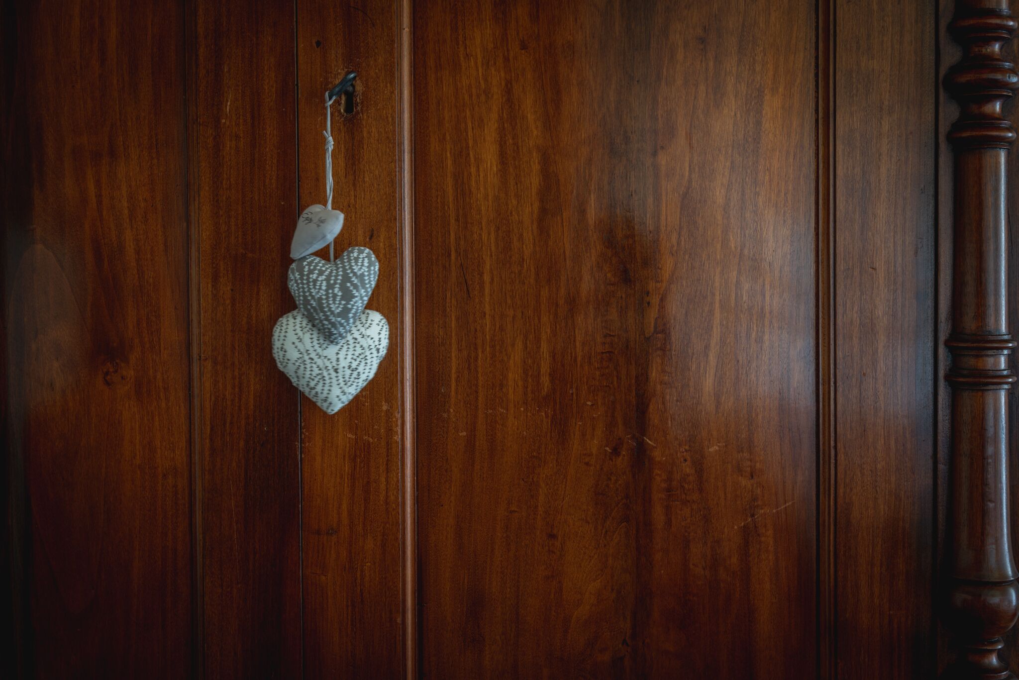 A wooden door with a heart-shaped ornament hanging on it.