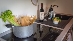 A kitchen with a pot of spaghetti, a bottle of wine, and a bowl of vegetables on the counter. - Agriturismo Podere Ceriano (Modigliana)
