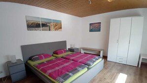 A bedroom with a bed, bedside tables, a wardrobe, and wall art. - Apartment in the countryside (Beilstein)