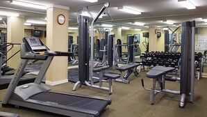 Un gimnasio con cintas de correr, máquinas de pesas y mancuernas.