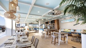 A spacious restaurant with high ceilings, hanging wicker chandeliers, and a view of the cityscape.