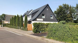 A modern two-story house with a dark grey roof and white exterior walls, featuring a sign that reads "Strandhaus Grömmlitz." - Strandhuus Grömitz (Groemitz)