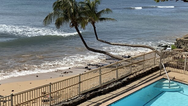 A pool with a view of the ocean and beach.