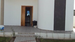 A modern building with a tiled pathway leading to a wooden door. - Luxurious villa with swimming pool in Midoun (djerba midoun)