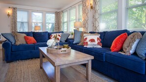 A living room with two blue sofas, a wooden coffee table, and a patterned rug.