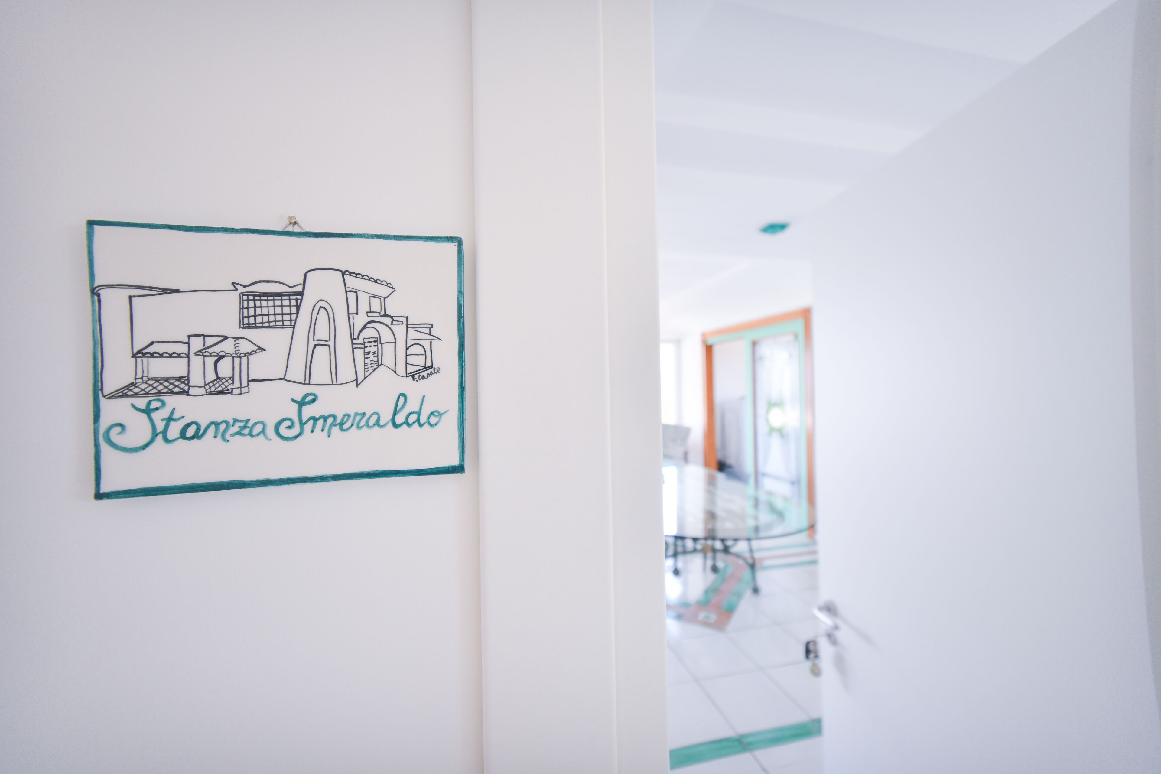 A wall with a framed drawing of a building and the text "Stanza Smeraldo".