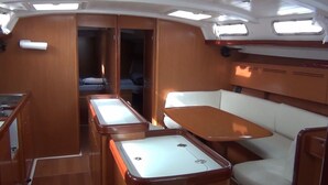 A compact galley with a dining table and bench seating, a small sleeping area, and a compact kitchenette. - Delfina (Lampedusa)