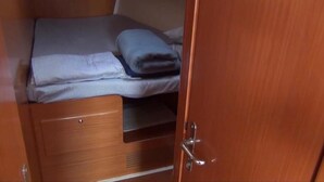 A wooden wardrobe with a bed and a folded blanket inside. - Delfina (Lampedusa)
