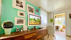 Aula, jossa on puinen vastaanottotiski, seinällä kehystettyjä valokuvia, televisio ja tuoli.