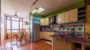 Une cuisine équipée d’un réfrigérateur, d’une cuisinière et d’un évier. On y trouve également un coin repas avec des chaises et une table.