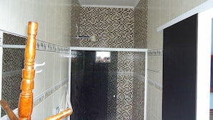 A bathroom with a checkered tile backsplash, a black mirror, and a wooden towel rack.