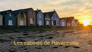 Une rangée de maisons aux couleurs vives, avec un coucher de soleil en arrière-plan.