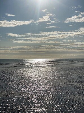 A beach with sunlight reflecting off the water. - Waterfront villa direct access to the beach (Saint-Marcouf)