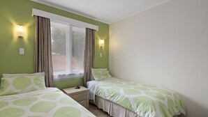 A bedroom with two beds, a window with curtains, and wall-mounted lights. - The Picton Family Retreat - Picton Unit (Picton)