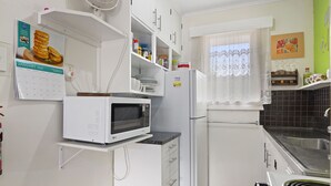 A kitchen with white cabinets, a microwave, a refrigerator, and a stove. - The Picton Family Retreat - Picton Unit (Picton)