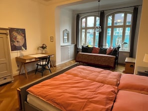 A bedroom with a bed, a desk, and a chair.